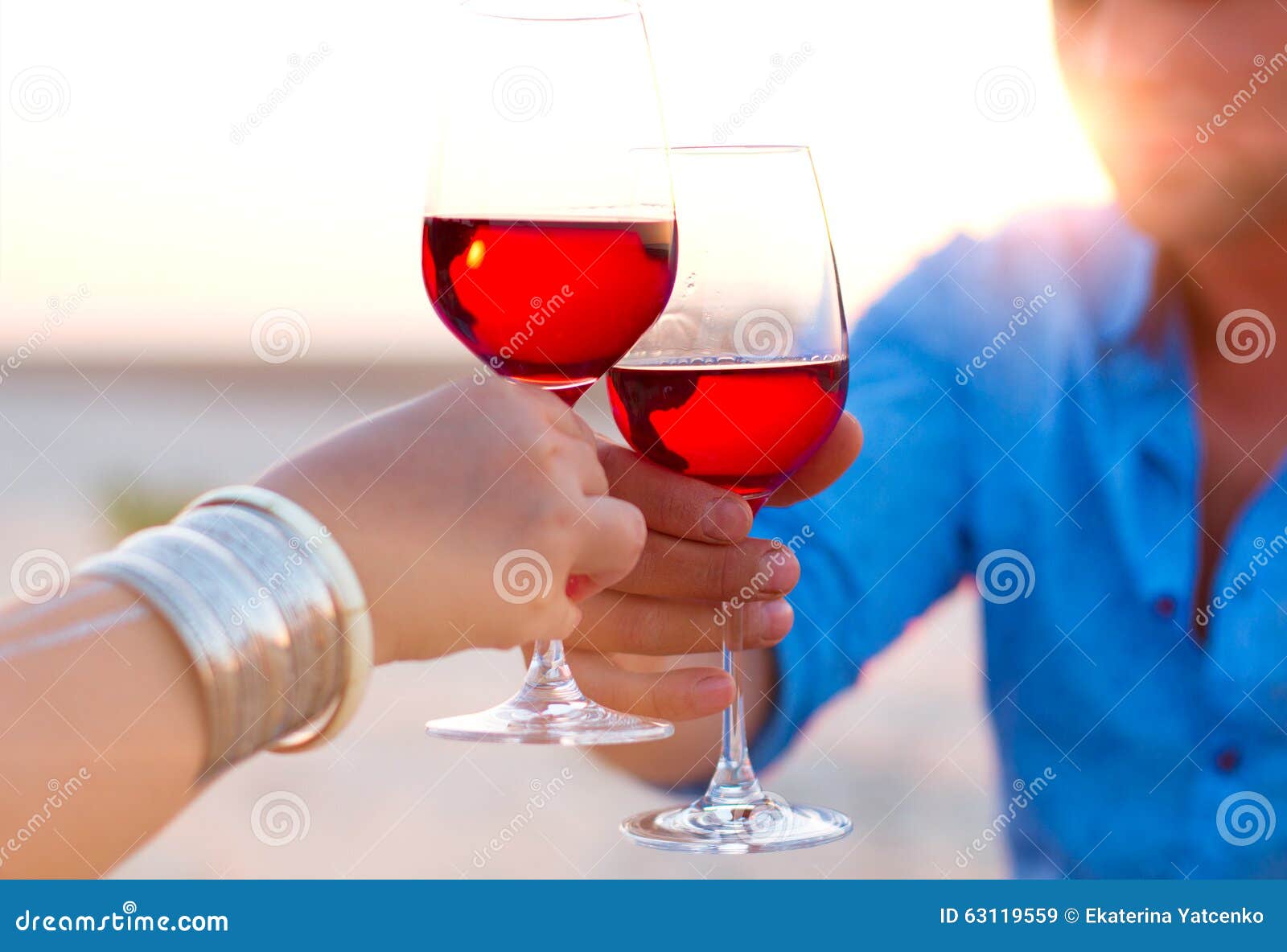close-up of two humanÃ¢â¬â¢s hand with wineglasses red wine during